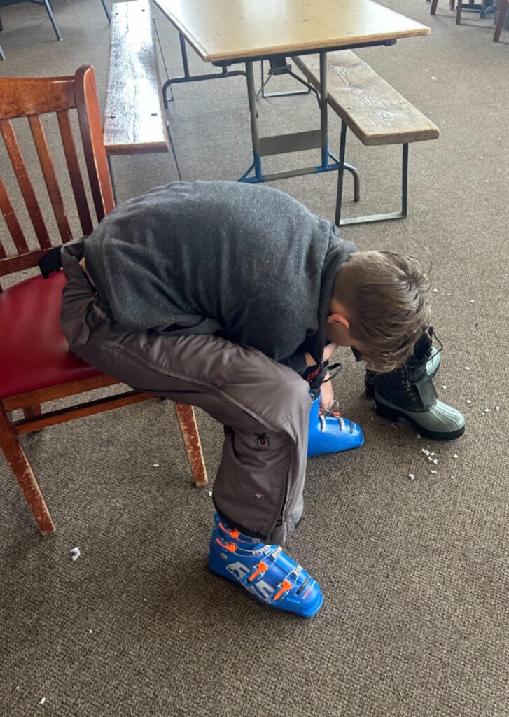 child putting on ski boots